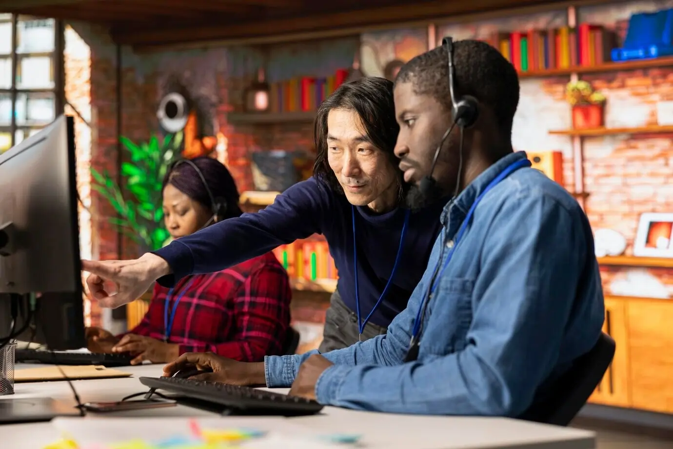 Leitender Callcenter-Manager, der einem multiethnischen Team Anleitung gibt.