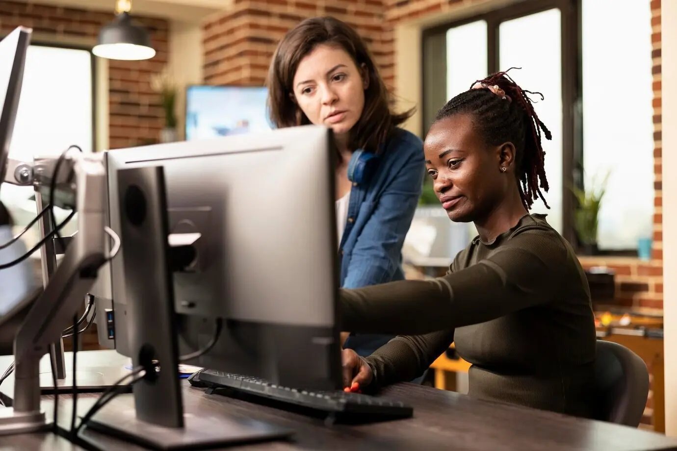 Ein Frauenteam wählt am Computer Designs aus.