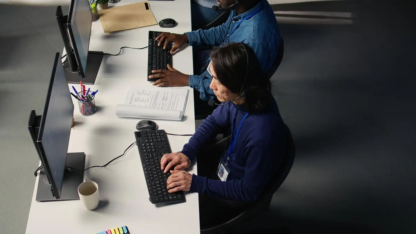 Callcenter-Mitarbeiter in einem vielfältigen Büro unterstützen Kunden.